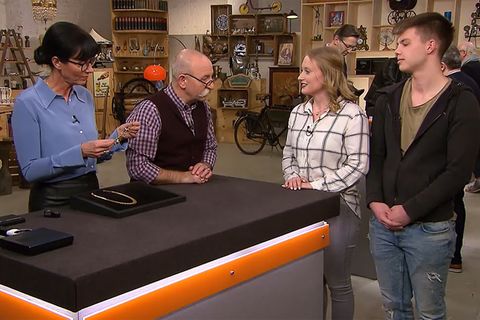 "Bares für Rares"-Expertin Heide Rezepa-Zabel nimmt den Schmuck von Joanna Baecker und Cedrik Scherdin in Augenschein. Moderator Horst Lichter plaudert mit den beiden Verkäufern.