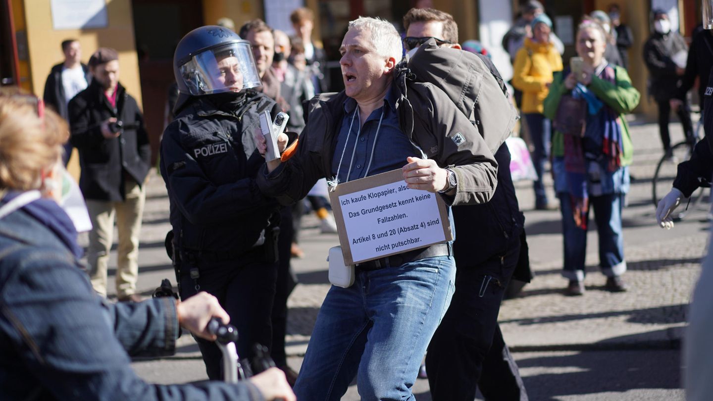 Ein Demonstrationsteilnehmer wird bei einer Demonstration auf dem Rosa-Luxemburg-Platz von Polizisten abgeführt