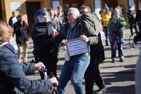 Ein Demonstrationsteilnehmer wird bei einer Demonstration auf dem Rosa-Luxemburg-Platz von Polizisten abgeführt