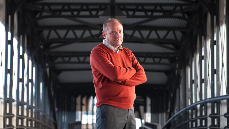 Andreas Heinecke Andreas Heinecke steht mit verschränkten Armen auf einer Hamburger Brücke