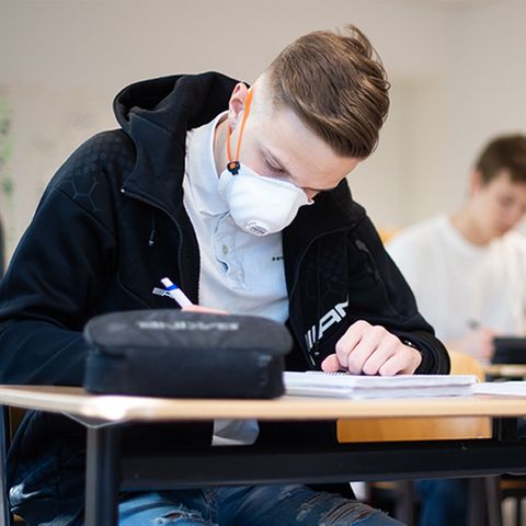 Schüler mit Mundschutz schreibt Abitur