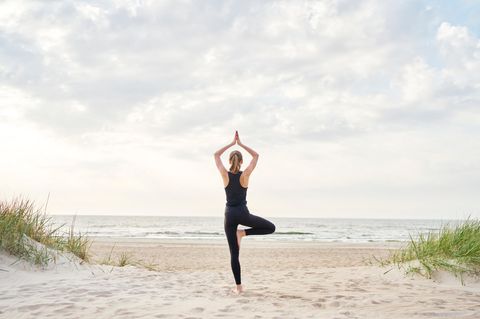 Frau meditiert am Strand