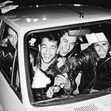 Junge Männer sitzen im Auto und strahlen