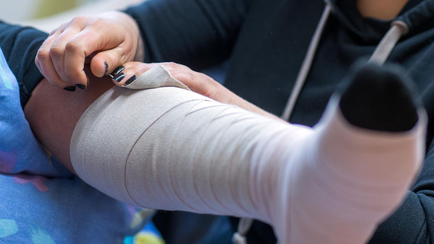 Eine Frau legt einer zu pflegende Person einen Thrombose-Verband an