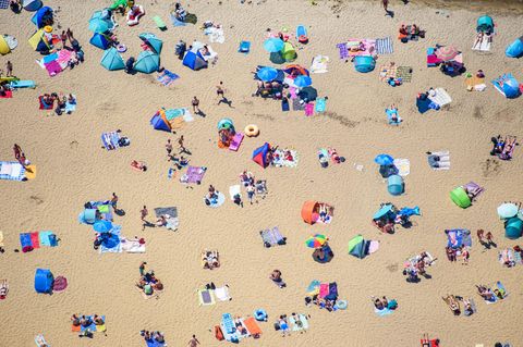 Menschen sonnen sich im am Sandstrand des Strandbad am Müggelsee (Archivfoto)