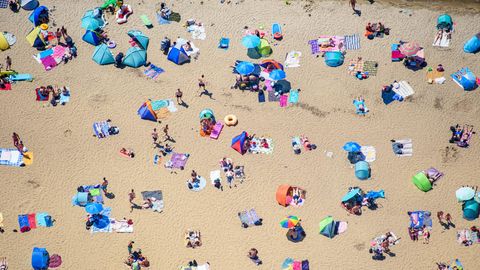Menschen sonnen sich im am Sandstrand des Strandbad am Müggelsee (Archivfoto)