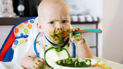 Ein Baby isst Spinat