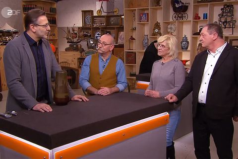 "Bares für Rares"-Experte Detlev Kümmel erklärt Moderator Horst Lichter und den Verkäufern Elke Bertram und Ralf Weber, wie die Vase gefertigt wurde.