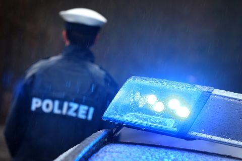 Ein Polizist und ein Polizeifahrzeug