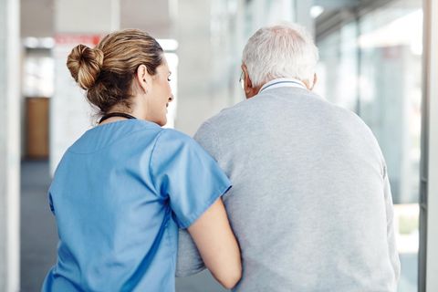 Krankenschwester stützt alten Mann