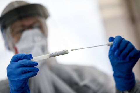 Eine Mitarbeiterin hält ein Abstrichstäbchen in einer ambulanten Corona Test-Einrichtung in der Hand