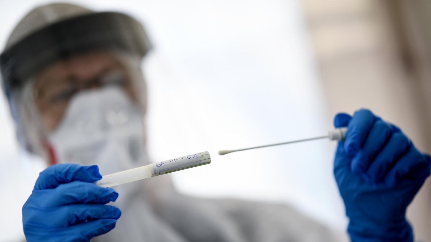 Eine Mitarbeiterin hält ein Abstrichstäbchen in einer ambulanten Corona Test-Einrichtung in der Hand