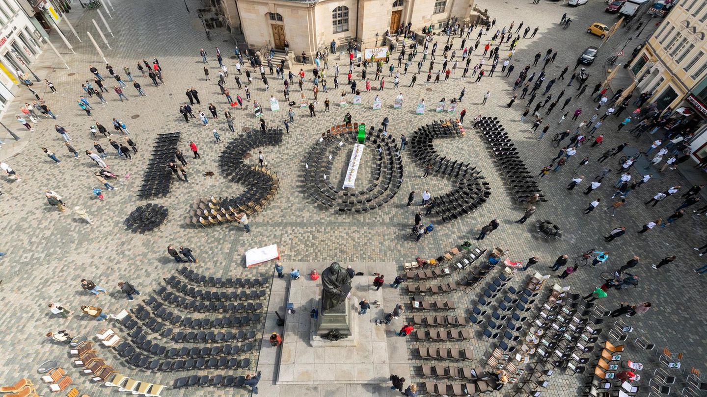 01.05.2020, Sachsen, Dresden: Die mit Stühlen gebildeten Buchstaben «SOS» stehen während einer Aktion, mit der die sächsische Gastronomie-, Hotel- und Eventbranche auf ihre Probleme durch die Auswirkungen der Coronavisus-Pandemie aufmerksam machen möcht... Gastwirte demonstrieren in Dresden