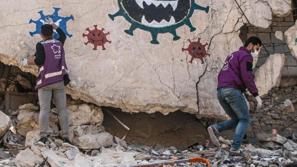 March 26, 2020: The photos show volunteers from Violet NGO drawing a painting on one of the walls destroyed by the bombing in the middle of Idlib governorate in northern Syria. The painting aims to educate people about the danger of the Corona virus and... Mit Graffiti warnen Helfer in Idlib vor Corona