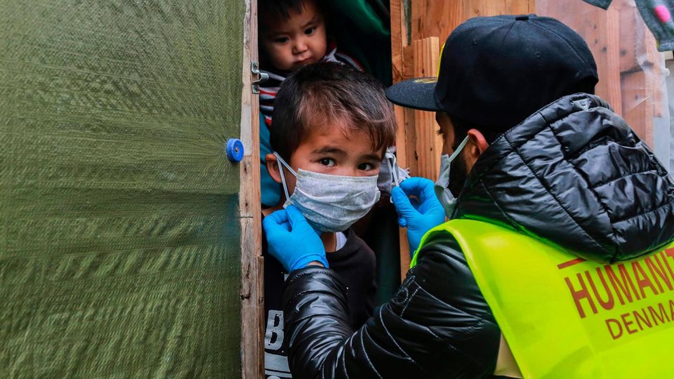 Hilfe für die Kleinsten: Ein Freiwilligenteam verteilt Gesichtsmasken an Kinder im Flüchtlingscamp Moria auf Lesbos Ein kleiner Junge erhält eine Schutz-Maske