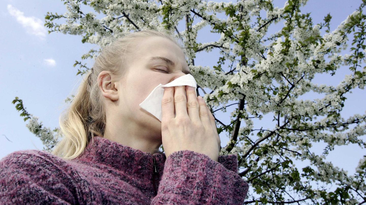 Eine Frau putzt sich die Nase