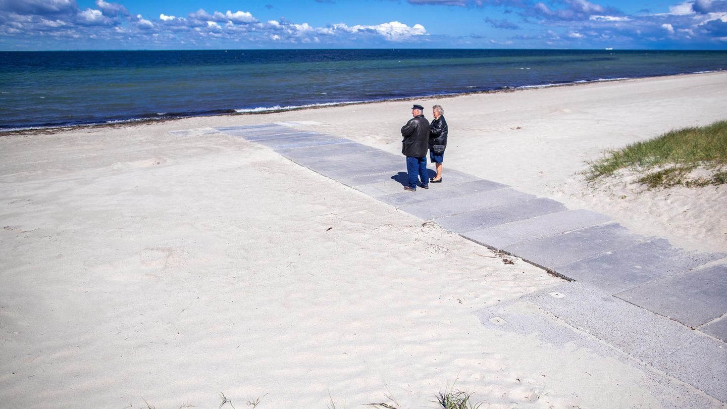 Rentnerpaar am ansonsten menschenleeren Strand in Timmendorf