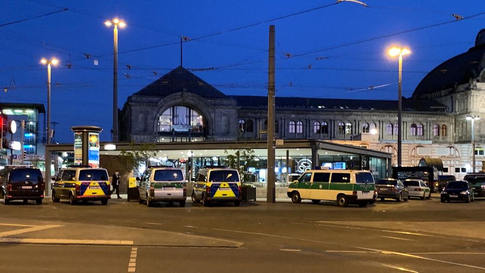 Im Dunklen stehen vor dem Hauptbahnhof in Nürnberg eine Reihe Polizeiwagen unter Laternen