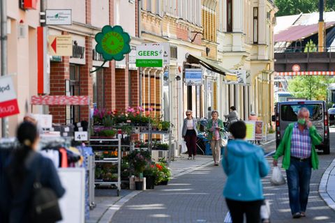 Thüringen, Greiz: Besucher der Innenstadt von Greiz gehen durch eine Einkaufsstraße im Zentrum der Altstadt
