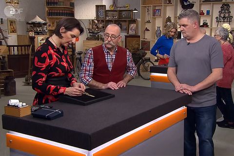 "Bares für Rares"-Expertin zeigt Moderator Horst Lichter die gute Verarbeitung des Goldarmbands von Frank Wolf.