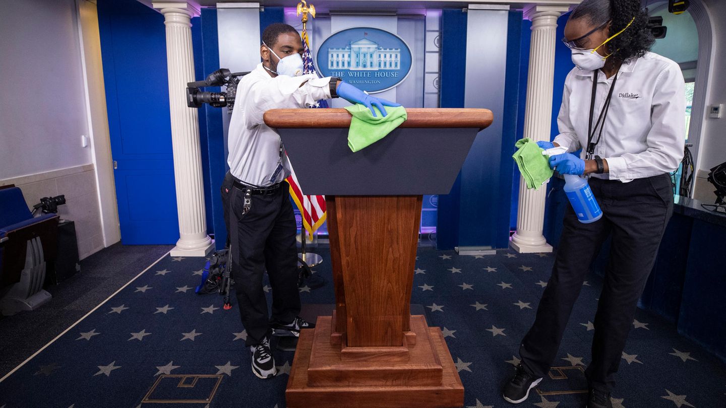Ein Reinigungsteam wischt das Rednerpult ab, bevor US-Präsident Trump spricht
