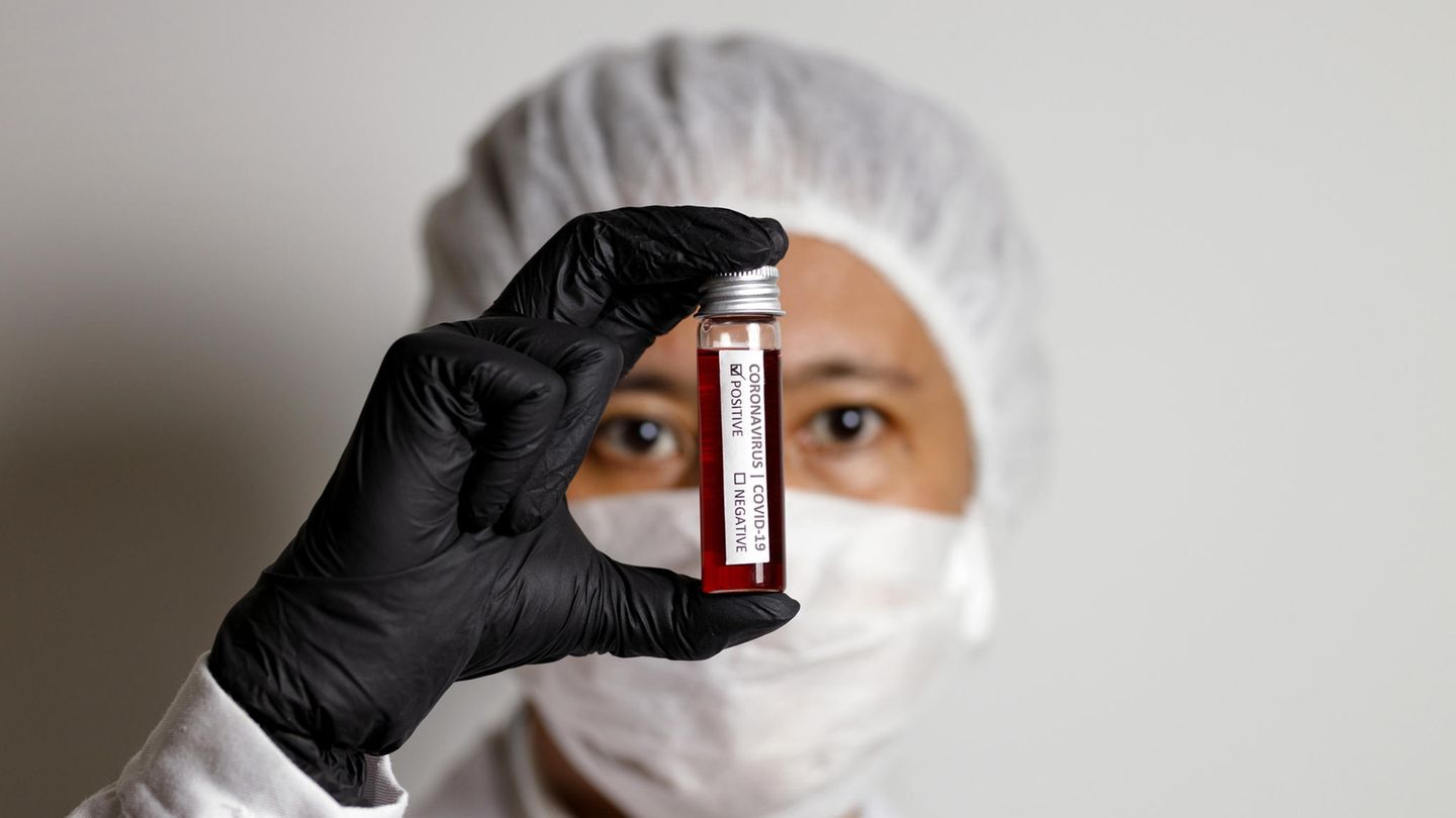 Eine Medizinerin hält eine Blutprobe in der Hand