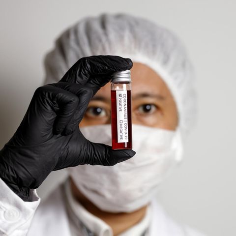 Eine Medizinerin hält eine Blutprobe in der Hand