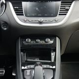 Ein aktuelles iPhone passt nur längs in das Fach. Induktiv wird unter der Armablage geladen