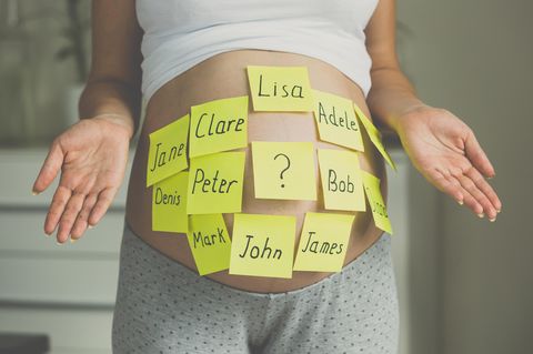 Schwangere mit Post-its auf dem Bauch, auf denen verschiedenen Vornamen stehen