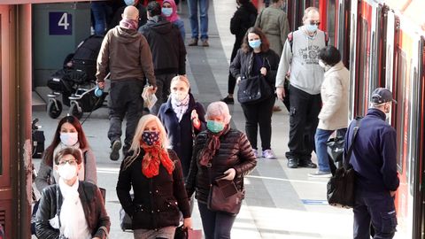 Mit Mundschutz sind Fahrgäste am Hamburger Hauptbahnhof auf einem Bahnsteig unterwegs
