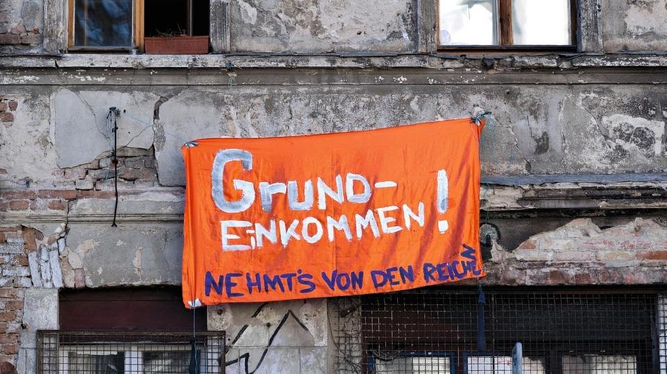 Ein Banner mit der Aufschrift "Grundeinkommen! Nehmt's von den Reichen"
