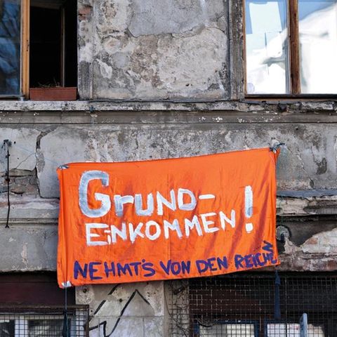 Ein Banner mit der Aufschrift "Grundeinkommen! Nehmt's von den Reichen"
