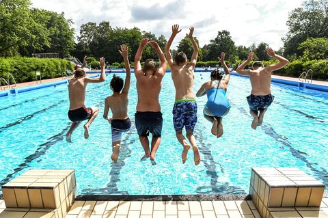 Kinder springen ins Freibad