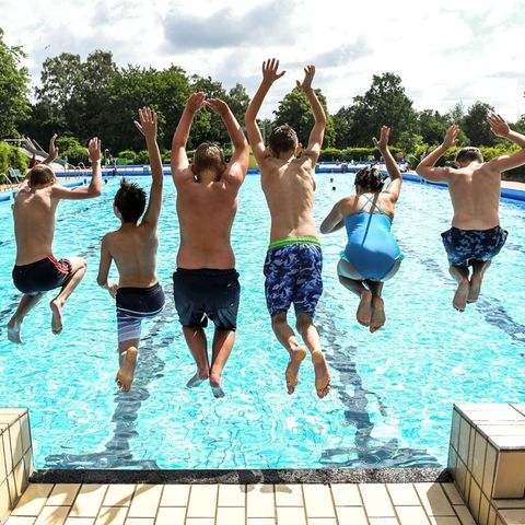 Kinder springen ins Freibad