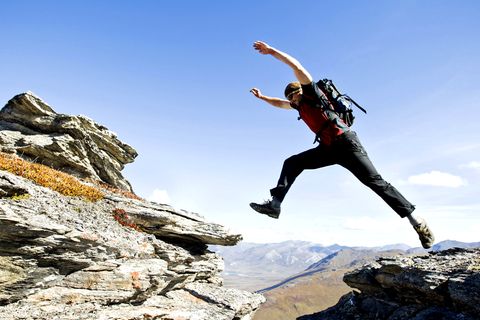 Brooks Range Traverse in Alaska, USA  Dieser siebentägige Tour durch die Wildnis ist nur etwas für Profis. Ein mutiger Wanderer springt entlang der Brooks Range Traverse über Felsspalten in der Nähe des Noatak River.