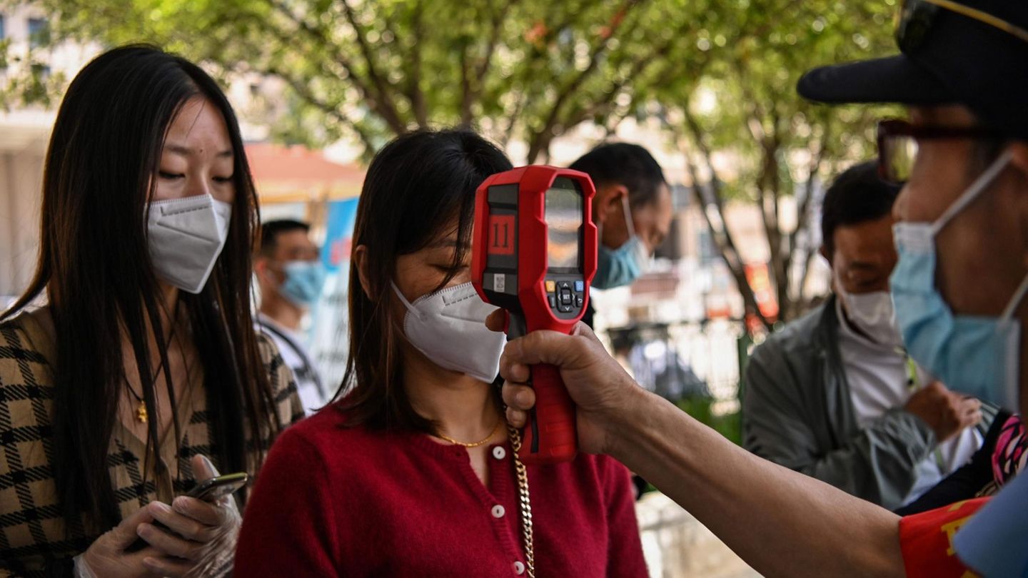 Bei einer Frau in Wuhan wird die Temperatur gemessen