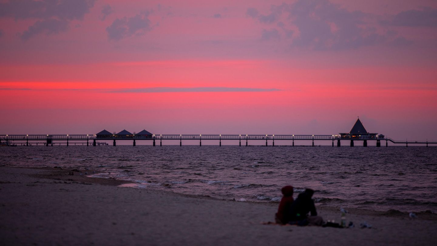 Ein Plan, keine Garantie: Die Hoffnung auf den Sommerurlaub stirbt zuletzt Die untergegangene Sonne färbt den Himmel über Strand und Seebrücke von Heringsdorf orangerot ein