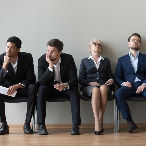Vom ihrem Job frustrierte Menschen auf einer Sitzbank.