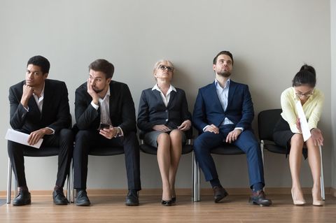 Vom ihrem Job frustrierte Menschen auf einer Sitzbank.