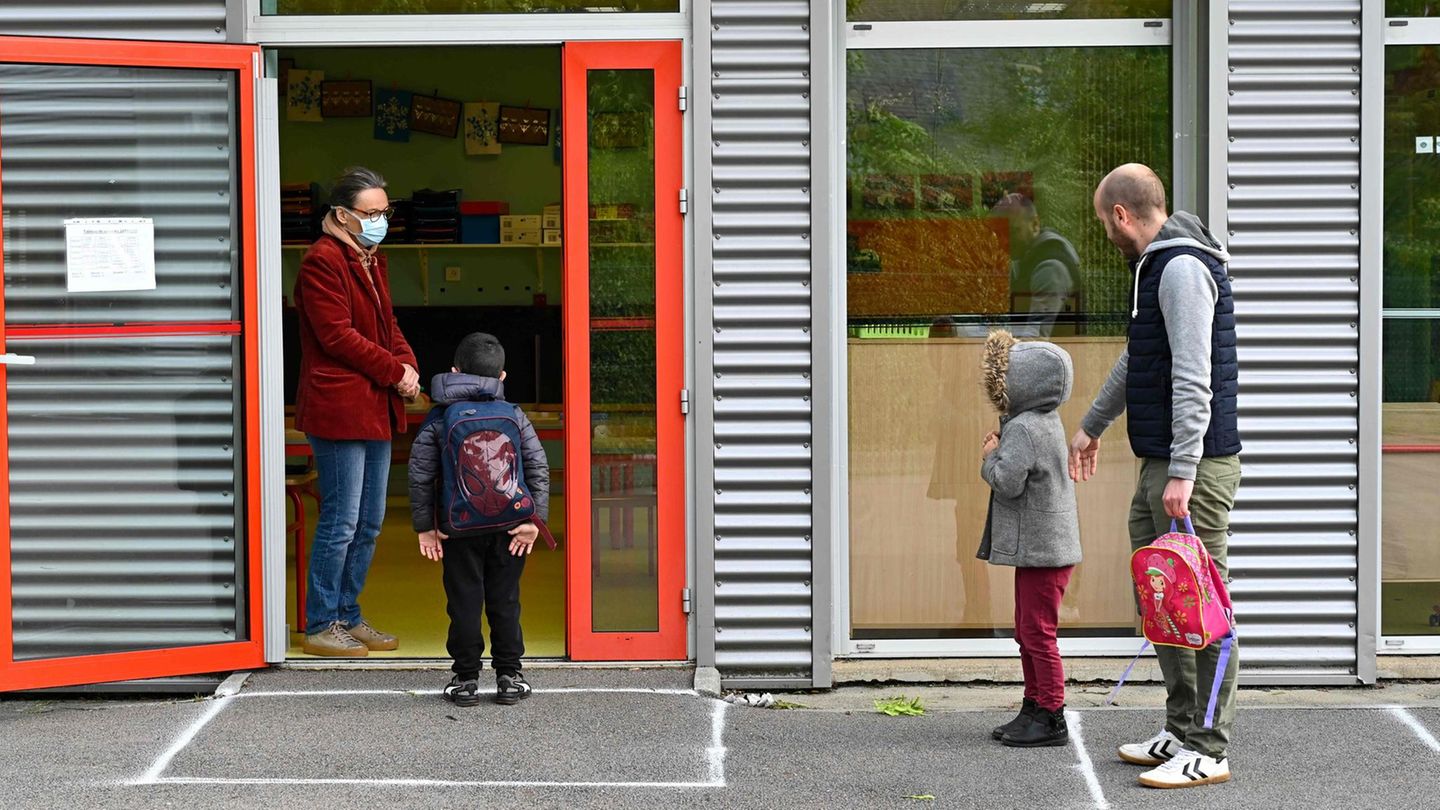 Schüler in Frankreich warten mit Abstand voneinander vor der Tür
