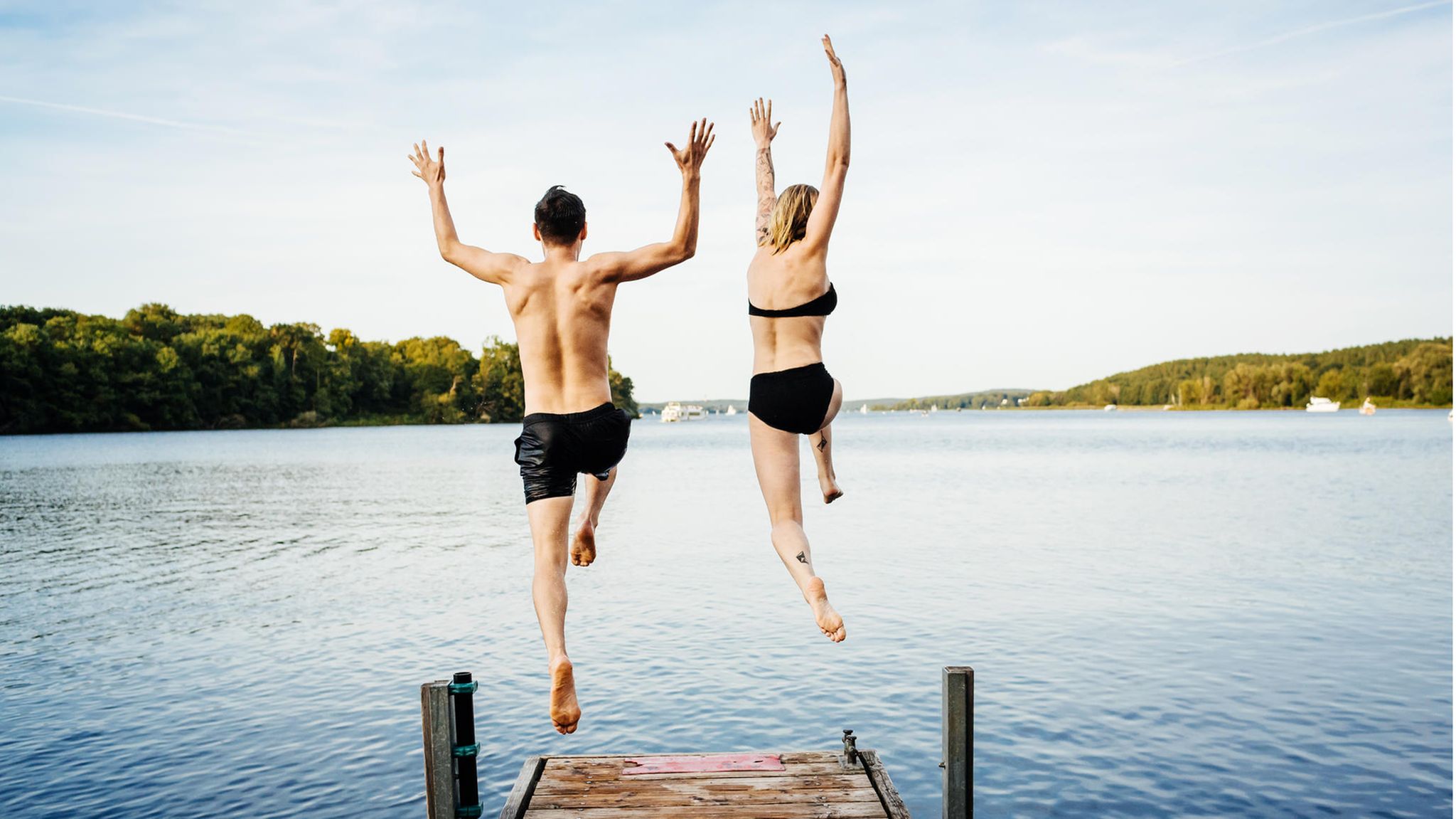 Zwei Menschen springen ins Wasser