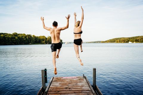 Zwei Menschen springen ins Wasser