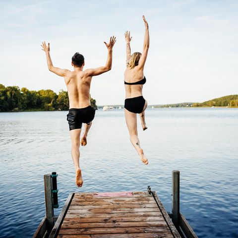 Zwei Menschen springen ins Wasser