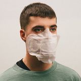 Ein junger Mann trägt eine Damenbinde als Atemschutzmaske