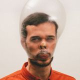 Ein junger Mann trägt ein Kondom über dem Kopf