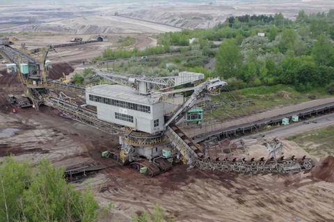Der Eimerkettenbagger 351 überquert mit dem dazugehörigen Bandwagen bei seinem Umzug in den Tagebau Profen eine Landstraße.