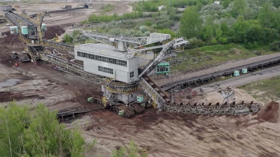 Der Eimerkettenbagger 351 überquert mit dem dazugehörigen Bandwagen bei seinem Umzug in den Tagebau Profen eine Landstraße.
