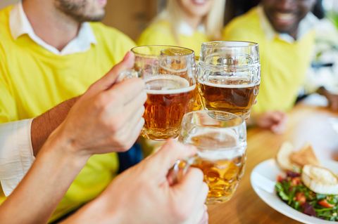Gäste im Restaurant stoßen mit Bier an