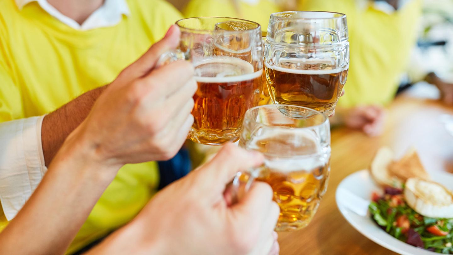 Gäste im Restaurant stoßen mit Bier an