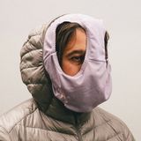 Eine junge Frau trägt eine Unterhose vor dem Gesicht